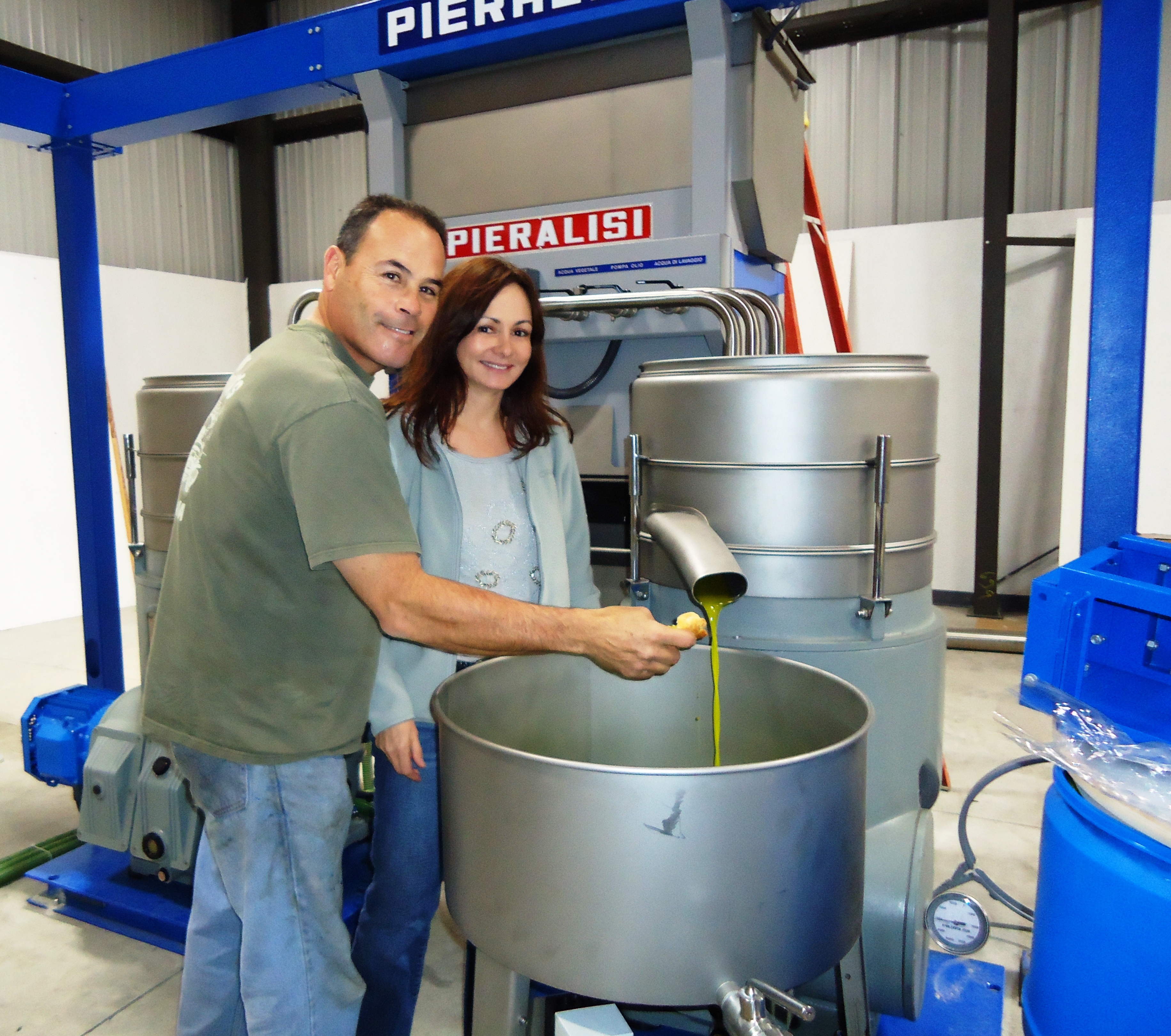 Frank and Marti Menacho taste their fresh olive oil in production.
